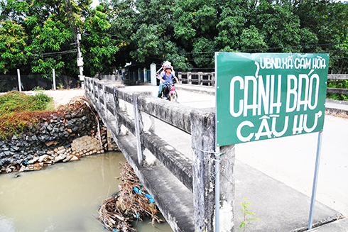 Cầu Làng bị sạt lở nghiêm trọng phần mố cầu, UBND xã Cam Hòa  phải cắm biển cảnh báo.