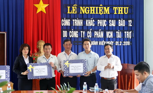 Lãnh đạo Công ty Cổ phần đầu tư VCN (thứ hai, bên phải) trao máy tính, máy chiếu cho Trường THCS Chu Văn An