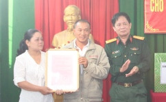 Đại tá Lê Văn Chín - Chính ủy Bộ CHQS tỉnh Khánh Hòa trao quyết định giao nhà cho gia đình ông Hùng.