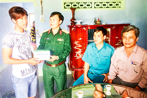Trung tá Đoàn Quách Tỉnh - Chính trị viên Ban Chỉ huy Quân sự  huyện Vạn Ninh tặng quà cho thanh niên trúng tuyển trước ngày nhập ngũ.