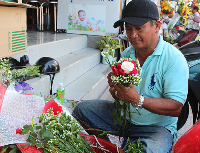 Một ông chủ shop hoa đang chuẩn bị hoa cho khách.