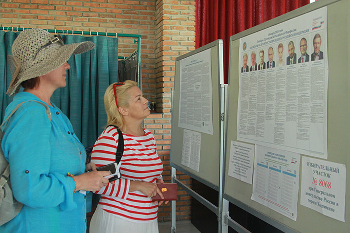 Voters looking through the broadsheet with information about the presidential contenders