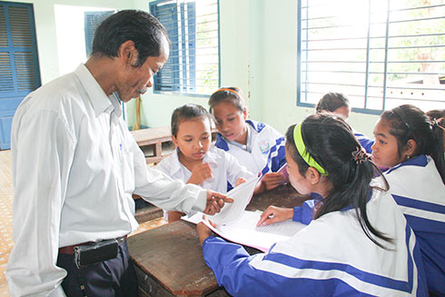 Nghệ nhân Ưu tú Mấu Quốc Tiến trong một buổi truyền dạy sử thi Raglai cho học sinh.