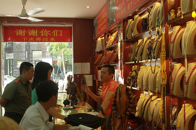 Anh Vượng (bên phải) - Chủ cơ sở Vượng Trầm Hương phân trần lý do anh viết tiếng Trung lên các tấm bảng trong và ngoài cửa hàng là để việc bán hàng được thuận lợi.