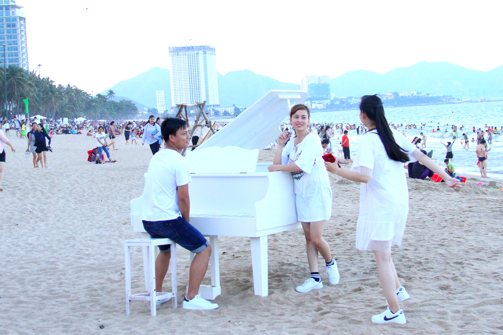 Tourists posing with model piano