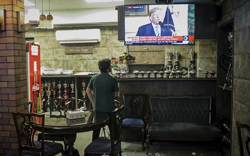 Một người dân tại thủ đô Tehran theo dõi Tổng thống Mỹ Donald Trump tuyên bố rút khỏi thỏa thuận hạt nhân 2015. Ảnh: Reuters