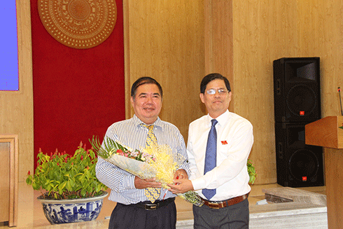 Ông Nguyễn Tấn Tuân (bên phải) tặng hoa cho ông Nguyễn Ngọc Minh