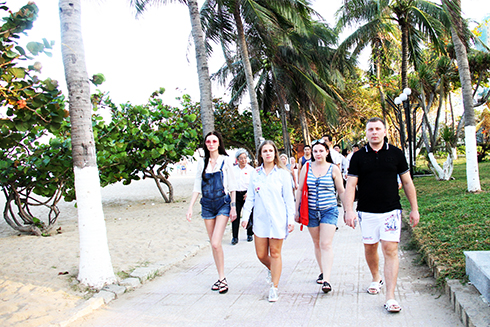 Foreign tourists strolling along beach park in Nha Trang