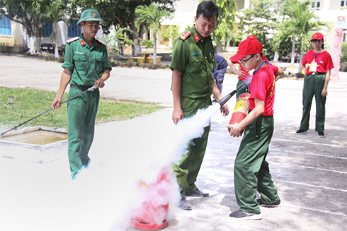 Các học viên thực hành dập tắt đám cháy bằng bình cứu hỏa. 