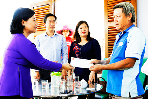 Lãnh đạo Trung ương Hội Nông dân (trái) thăm hỏi, động viên Tổ hợp tác nuôi gà nòi thương phẩm Ninh An sau cơn bão số 12.