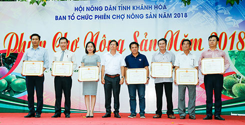 Đồng chí Nguyễn Tấn Tuân trao bằng khen của UBND tỉnh cho các tập thể, cá nhân xuất sắc trong phiên chợ.