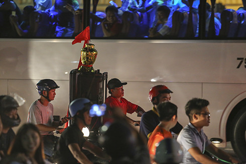 Chiếc cúp vô địch được người dân chở đi bằng xe máy để cổ vũ cho đội tuyển Olympic Việt Nam.