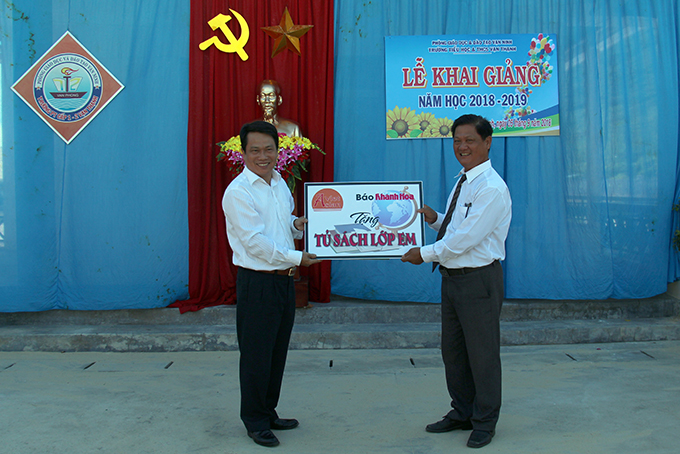 Ông Trần Duy Hưng – Tổng Biên tập Báo Khánh Hòa (bên trái) tặng Tủ sách lớp em cho Trường Tiểu học và Trung học cơ sở Vạn Thạnh.