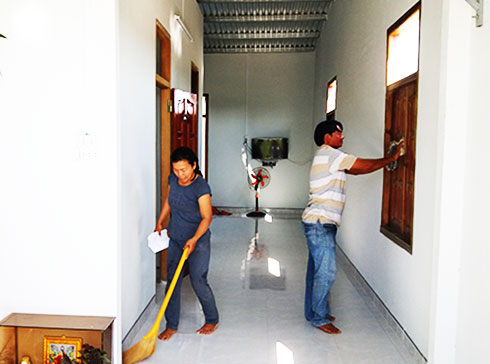 Vợ chồng ông Nguyễn Đức Thành lau dọn nhà mới  để chuẩn bị chuyển vào ở.