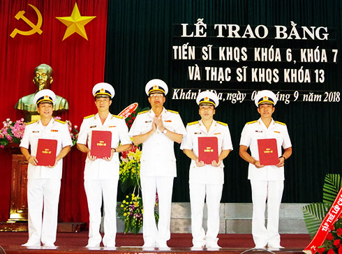 Đại tá Nguyễn Đức Nam trao bằng tiến sĩ cho các nghiên cứu sinh.