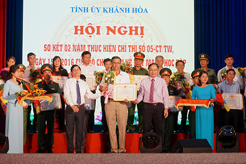 Ông Nguyễn Tấn Tuân và ông Nguyễn Đắc Tài trao bằng khen và tặng hoa chúc mừng các tập thể. 