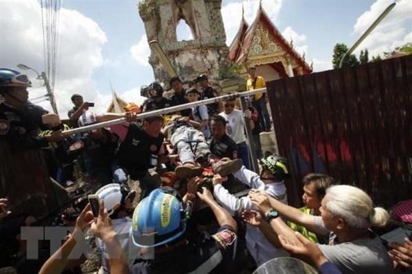Lực lượng cứu hộ chuyển công nhân bị thương ra khỏi đống đổ nát tại hiện trường vụ sập tháp chuông. (Nguồn: Bangkok Post/TTXVN)