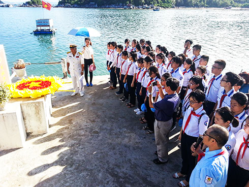 Học sinh Trường THCS Võ Văn Ký tham gia đặt vòng hoa tưởng niệm tại di tích tàu không số Vũng Rô, Phú Yên. Ảnh: Thanh An