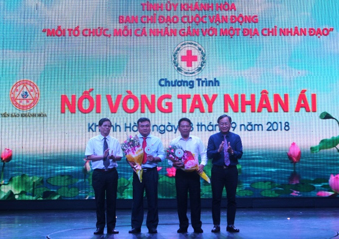 Ông Nguyễn Tấn Tuân và ông Nguyễn Đắc Tài tặng hoa cảm ơn 2 đơn vị tài trợ cho chương trình.