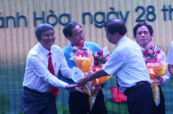 Ông Nguyễn Tấn Tuân tặng hoa, biểu trưng ghi nhận sự đóng góp của các đơn vị, doanh nghiệp.