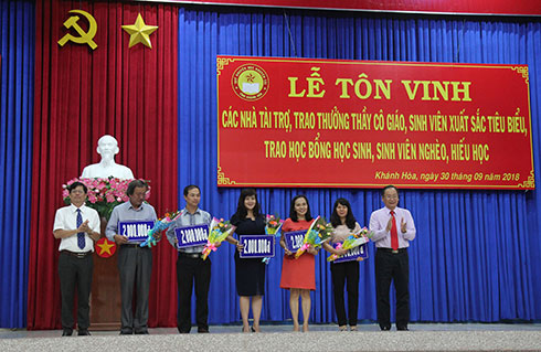 Ông Nguyễn Tấn Tuân và ông Nguyễn Đắc Tài khen thưởng các giáo viên. 