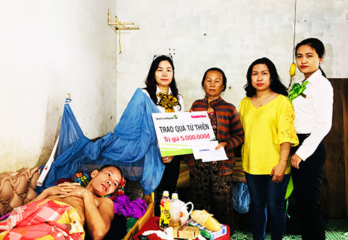 Đại diện Báo Khánh Hòa và Ngân hàng Vietcombank Nha Trang  trao tiền ủng hộ cho gia đình anh Võ Văn Hổ.