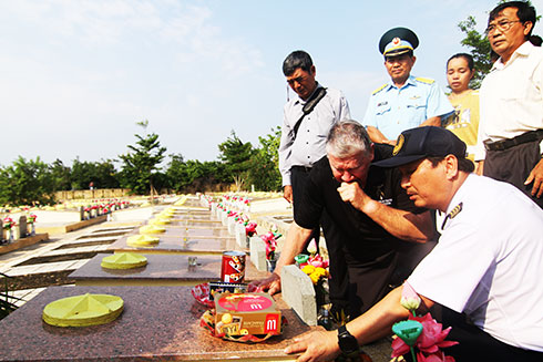 Ông Cunningham quỳ bên mộ liệt sĩ Trà Văn Kiếm. 
