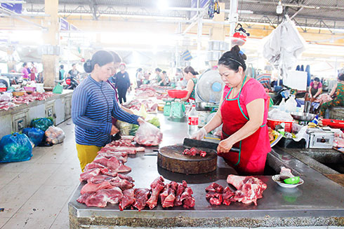 Một sạp thịt heo ở chợ Vĩnh Hải đã chuyển từ bày bán trên bìa các-tông sang mặt bàn bọc inox. 