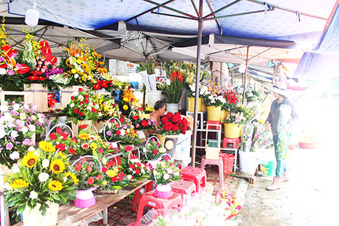 Một shop hoa tươi ở chợ Xóm Mới gói sẵn những lẵng hoa nhỏ  phục vụ thị trường quà tặng 20-10.