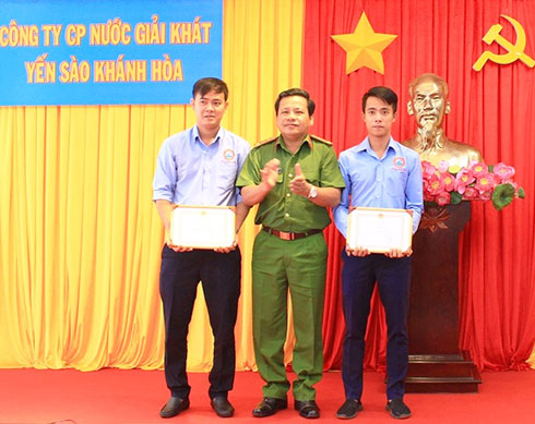Đại tá Võ Văn Dũng - Phó Giám đốc Công an tỉnh trao quyết định khen thưởng cho 2 anh Nguyễn Đức Nguyên và Nguyễn Đức Phong.