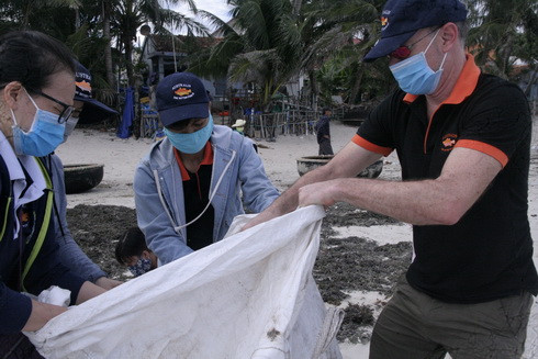 Ông Josh Golman (bên phải), Tổng Giám đốc Công ty TNHH Thủy sản Australis Việt Nam cùng các nhân viên cùng tham gia làm sạch bãi biển.