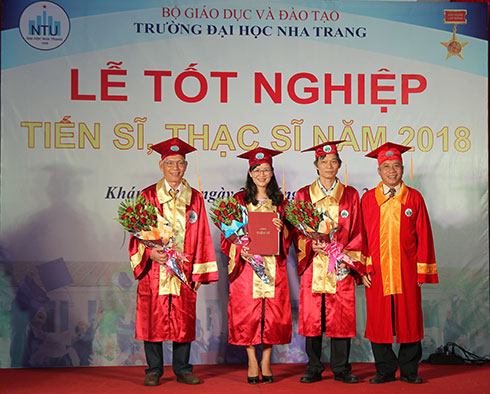 Lãnh đạo nhà trường trao bằng tốt nghiệp cho tân tiến sĩ.