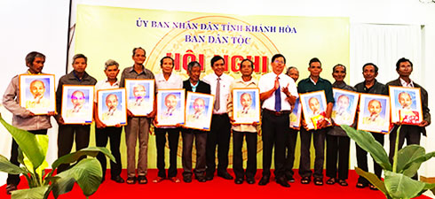 Những người có uy tín trong đồng bào dân tộc thiểu số nhận ảnh Bác và cờ.