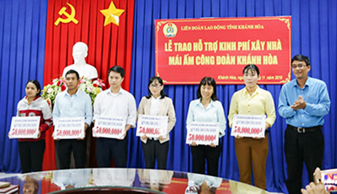 Trao bảng tượng trưng hỗ trợ xây mái ấm công đoàn cho các đoàn viên. 