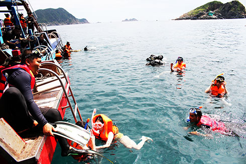 Khách du lịch trải nghiệm dịch vụ lặn biển  ở Hòn Mun, Nha Trang.