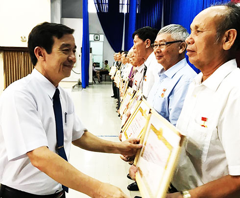 Ông Nguyễn Thế Sinh - Phó Bí thư Thường trực  Thành ủy Nha Trang trao tặng Huy hiệu Đảng cho  các đảng viên 50 năm tuổi Đảng.