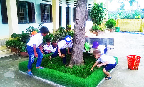 Học sinh Trường Tiểu học Khánh Bình dọn vệ sinh bồn cây.