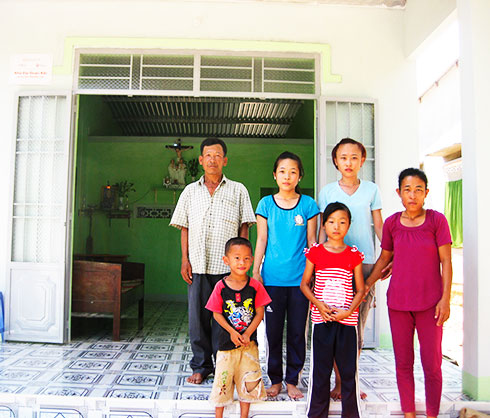 Gia đình ông Lê Ếch - xã Diên Xuân bên căn nhà đại đoàn kết do các  doanh nghiệp hỗ trợ xây dựng.