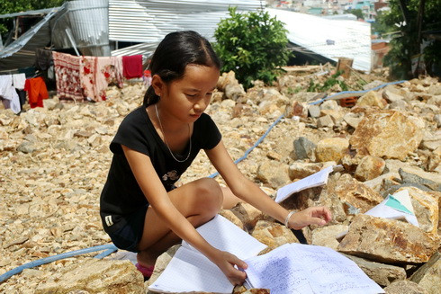 Nữ sinh lớp 6 Trường THCS Lê Thanh Liêm cẩn thận phơi sách vở trên đá.