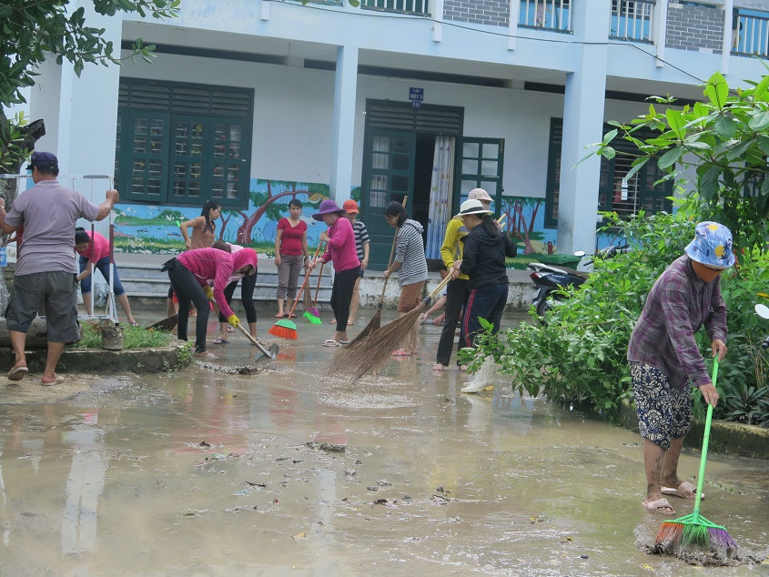 Tập thể cán bộ, giáo viên Trường Tiểu học Phước Đồng dọn dẹp trường học. 