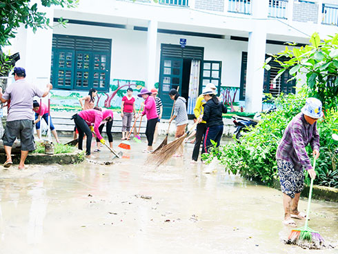 Tập thể cán bộ, giáo viên Trường Tiểu học Phước Đồng  dọn dẹp trường học.  