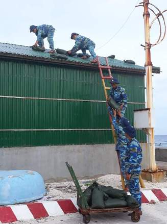 Cán bộ, chiến sĩ chằng chống mái nhà.