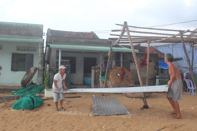 Tháo dỡ mái tôn hàng quán để tránh bão vào gây hư hỏng.