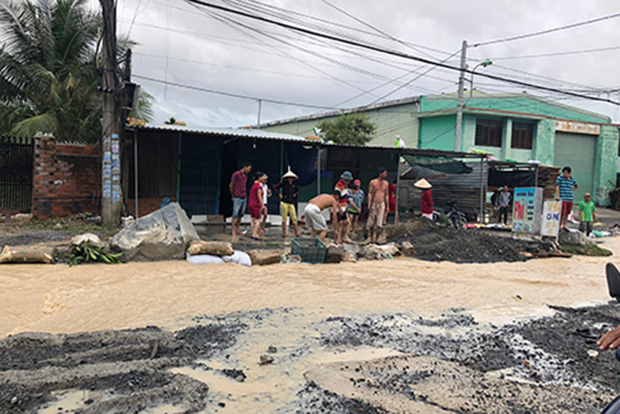 Người dân dọc Tỉnh lộ 3 đi qua xã Phước Đồng thu dọn đất đá tràn vào nhà