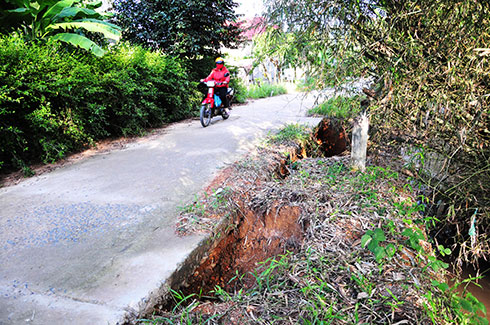 Một đoạn đường bê tông ở xã Suối Cát  bị cuốn trôi đất đá bên dưới làm hở hàm ếch.