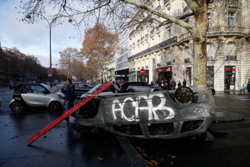 Những chiếc xe của người dân bị lật và đốt trên đại lộ Foch ở thủ đô Paris. Ảnh: Reuters.