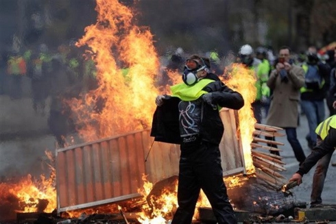 Người biểu tình áo vàng đốt phá trong cuộc biểu tình phản đối việc tăng giá nhiên liệu ở thủ đô Paris. Nguồn: AFP.