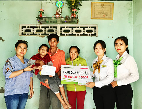 Representatives of Khanh Hoa Newspaper and Vietcombank Nha Trang offering money to Tan Sang’s family.