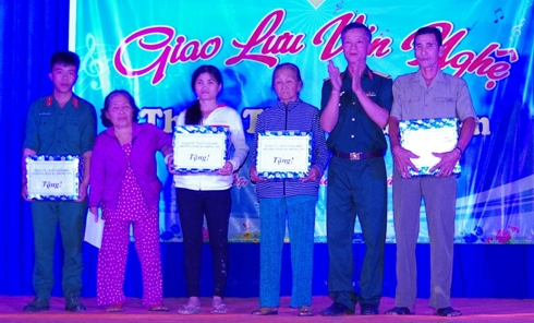 Lãnh đạo nhà trường trao quà cho người dân.