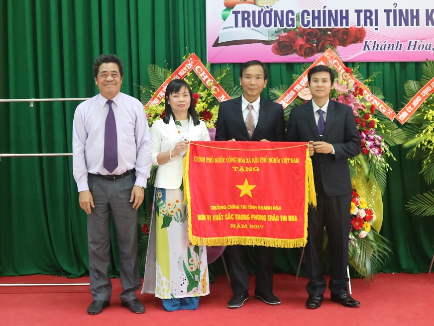Ông Lê Thanh Quang trao cờ thi đua của Thủ tướng Chính phủ cho nhà trường. 